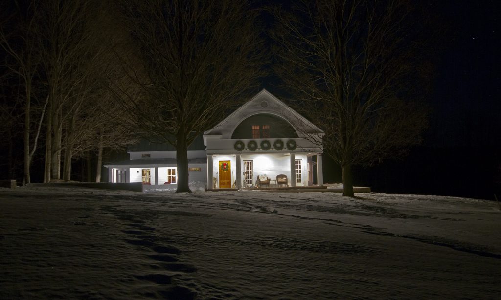A winter photo of the Spencer-Kielman house at night.